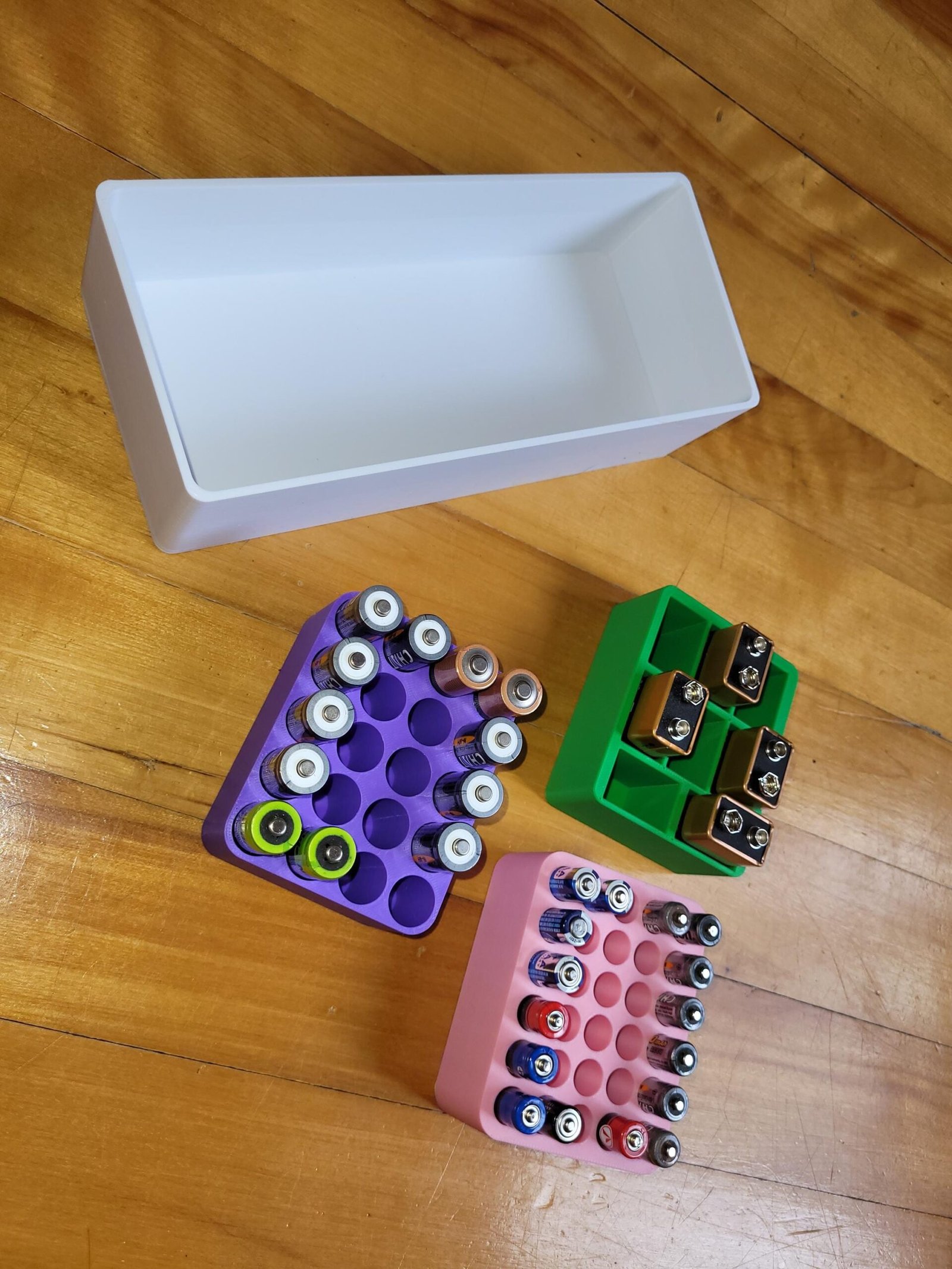 Battery organizer trays shown in multiple solid colours