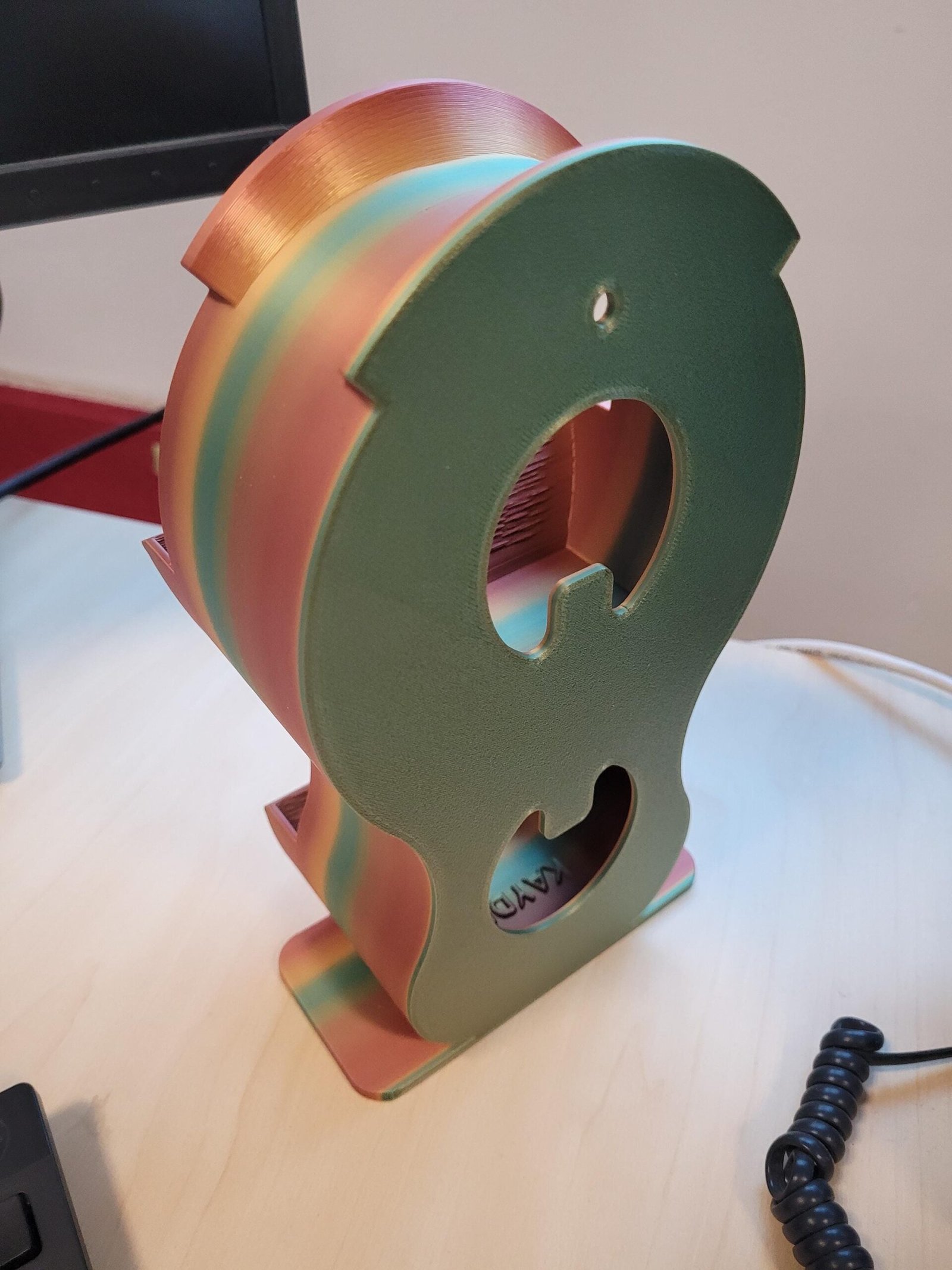 Metallic headphone holder shown holding headphones