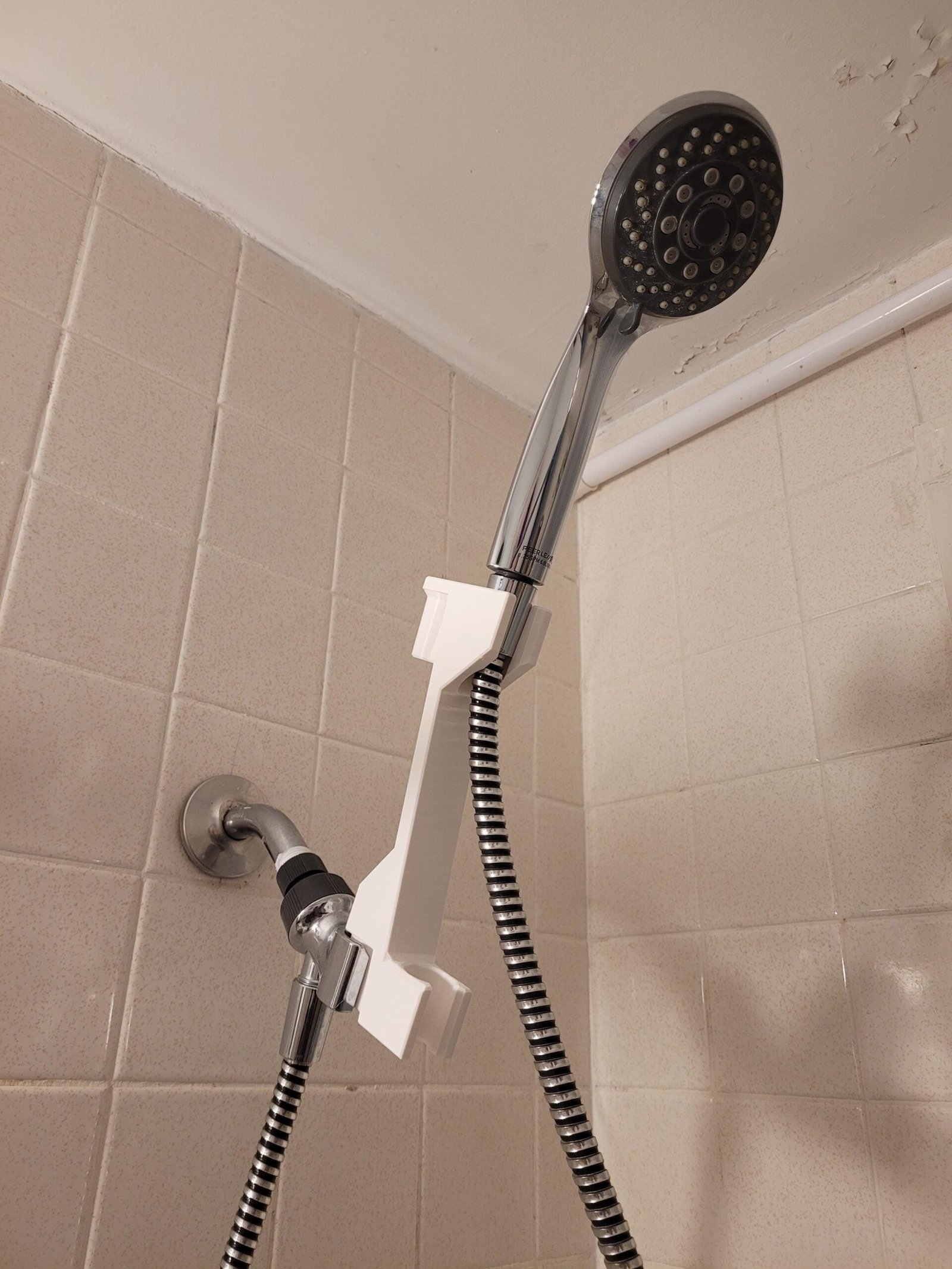 Close-up of the white shower head height adjuster hook