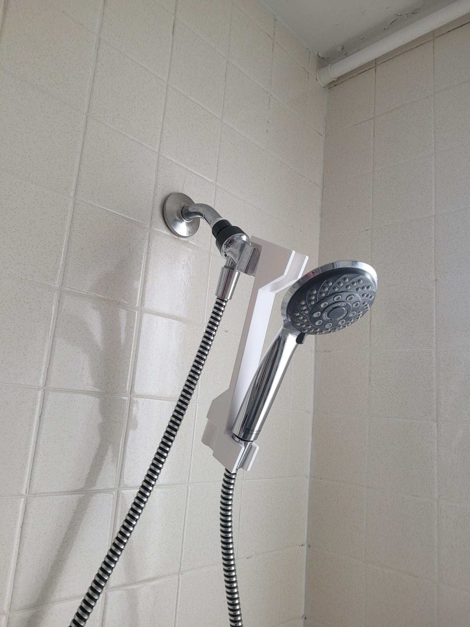 Size comparison of the white shower head height adjuster
