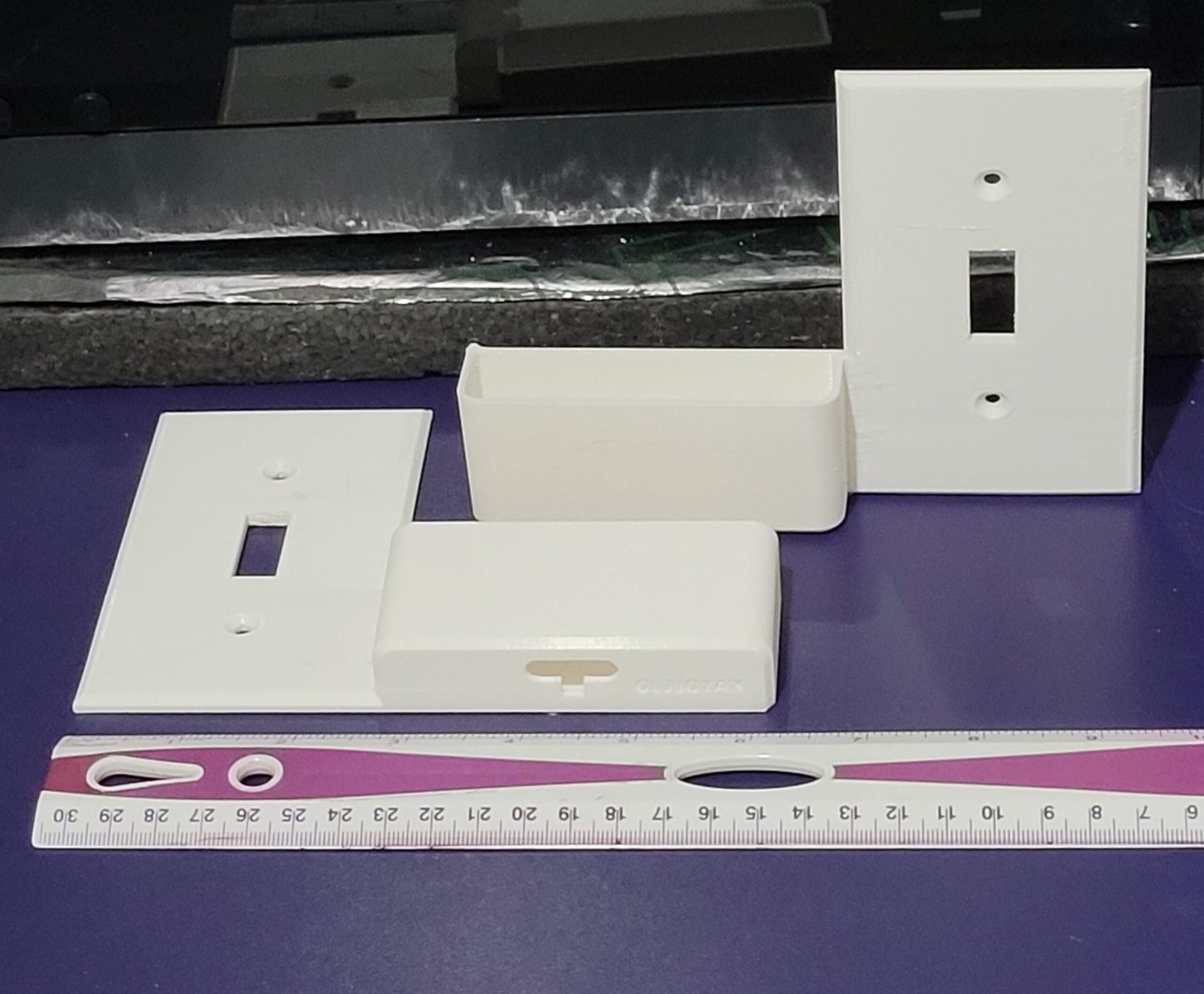 Angled view of the wall switch plate phone holder