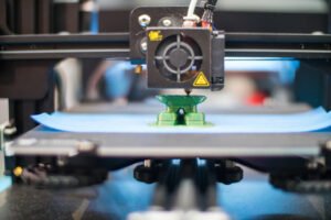 Close-up of a 3D printer extruding plastic filament